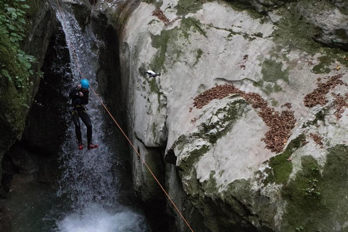 a person on a rope in front of a waterfall