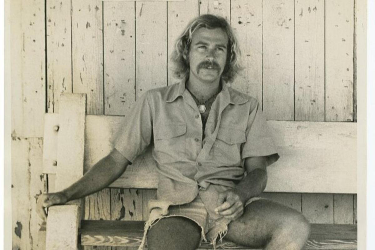 an old photo of a man sitting on a bench