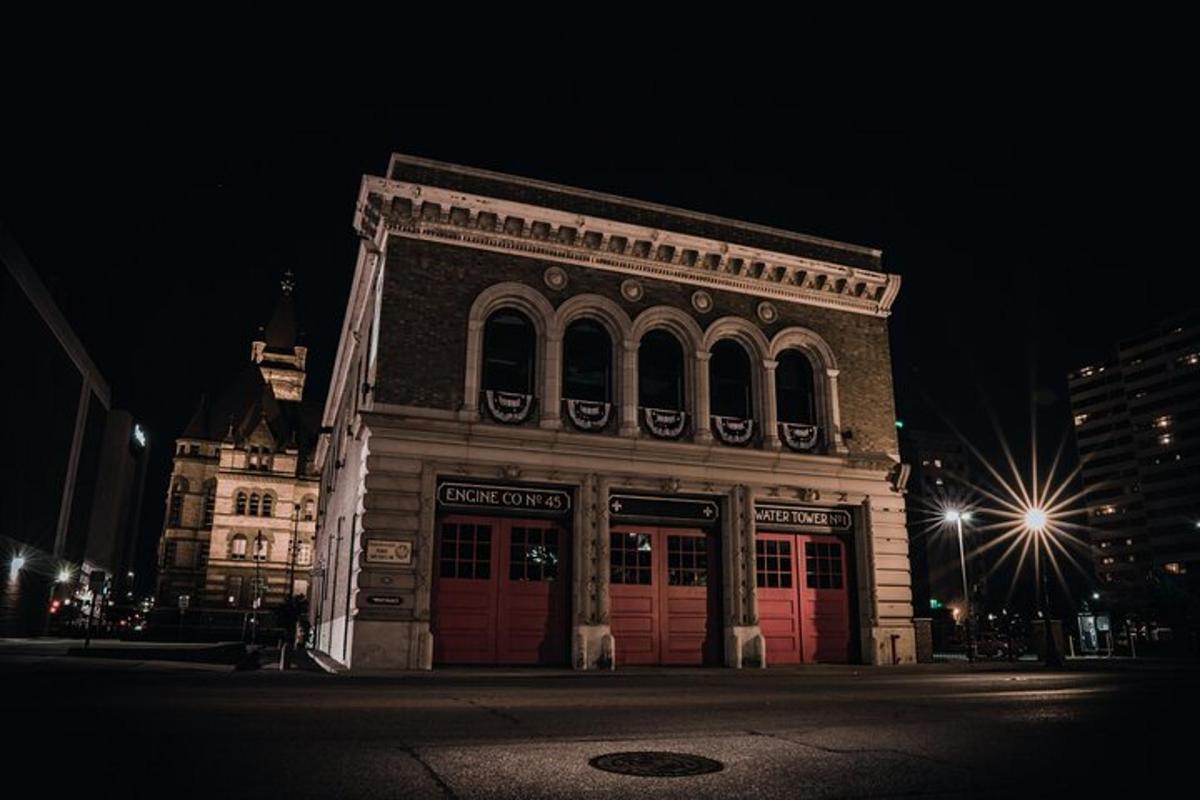 a large building with red doors on a street at night