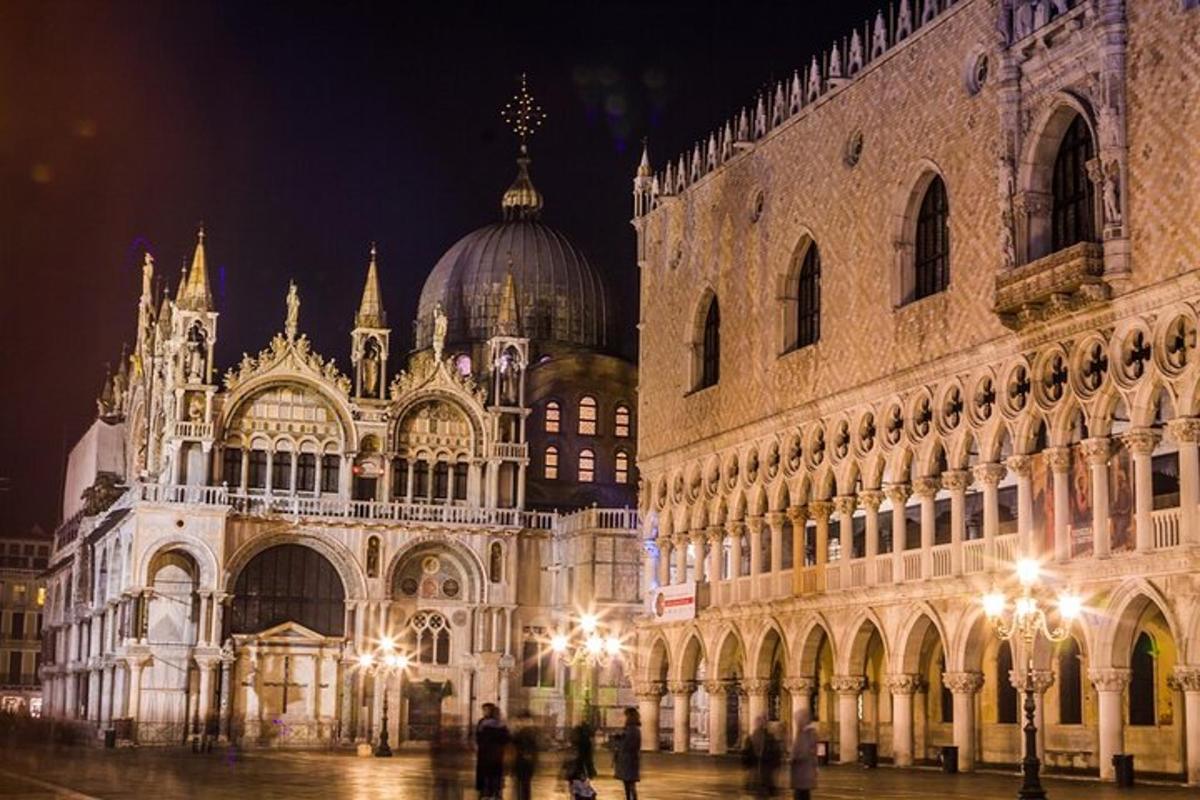 un grande edificio con persone in piedi di fronte ad esso di notte
