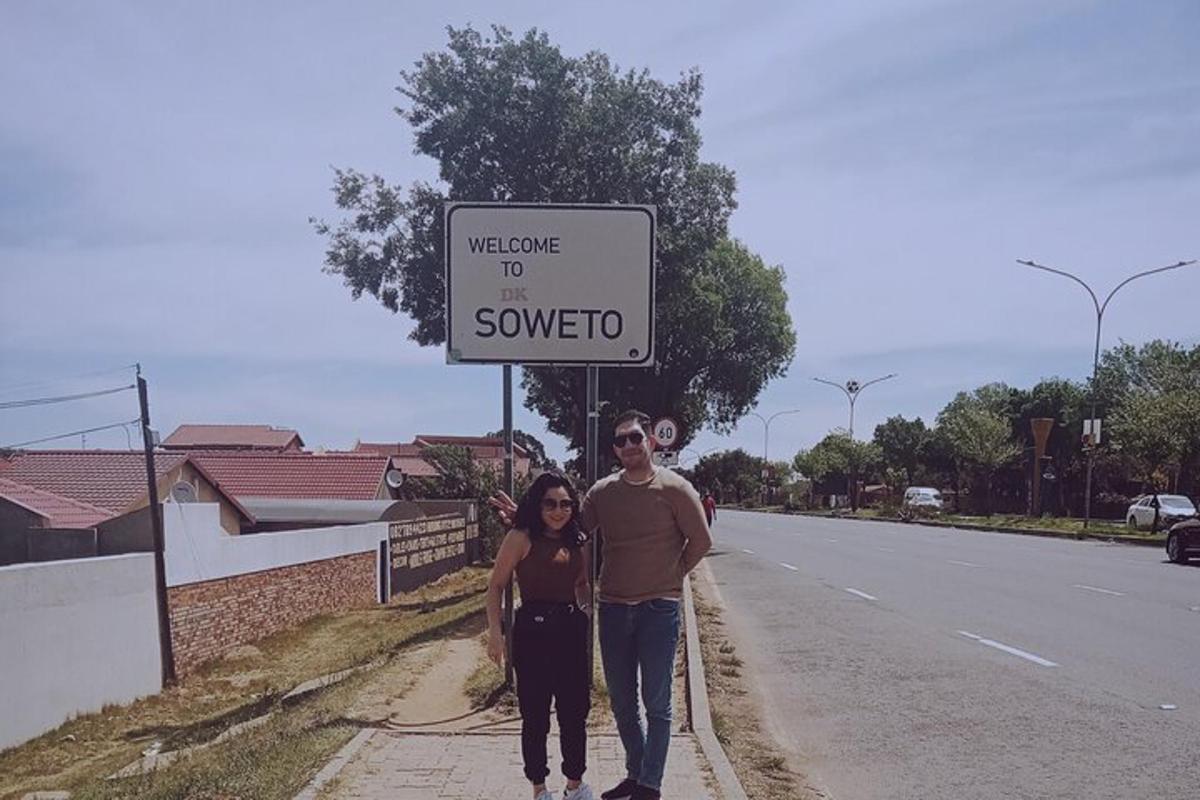 a man and a woman standing in front of a sign