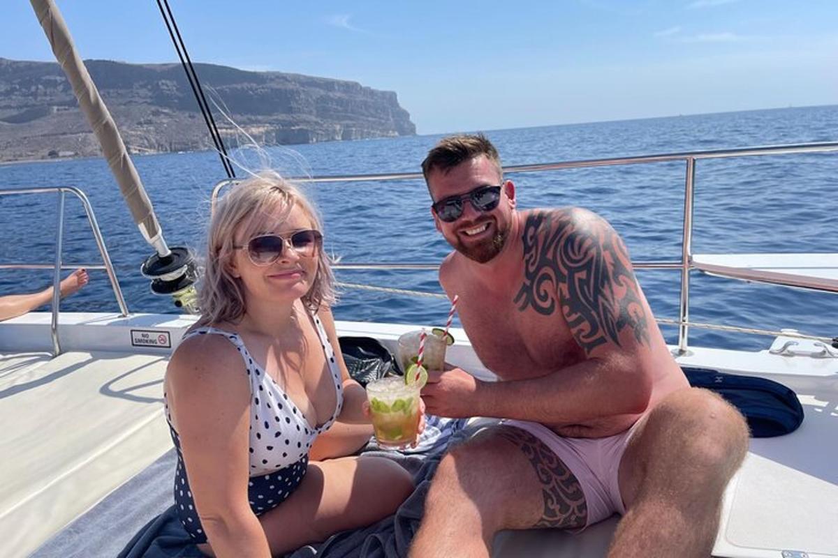 muž a žena sedící na lodi s drinkem