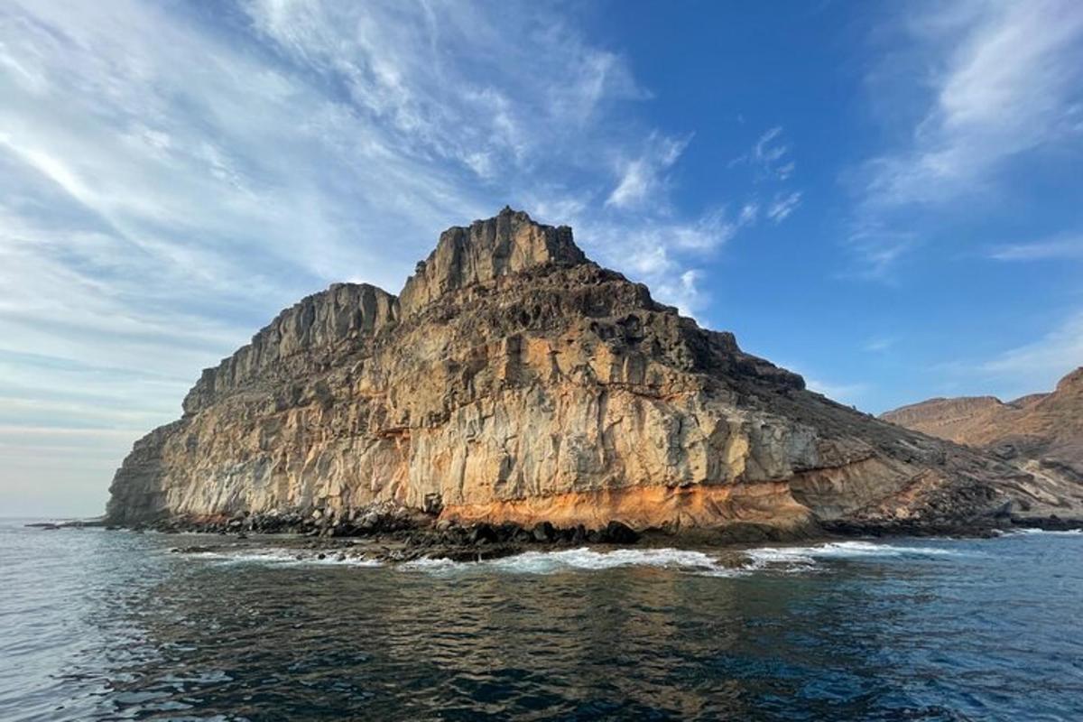 una gran illa rocosa a l'aigua sota un cel ennuvolat