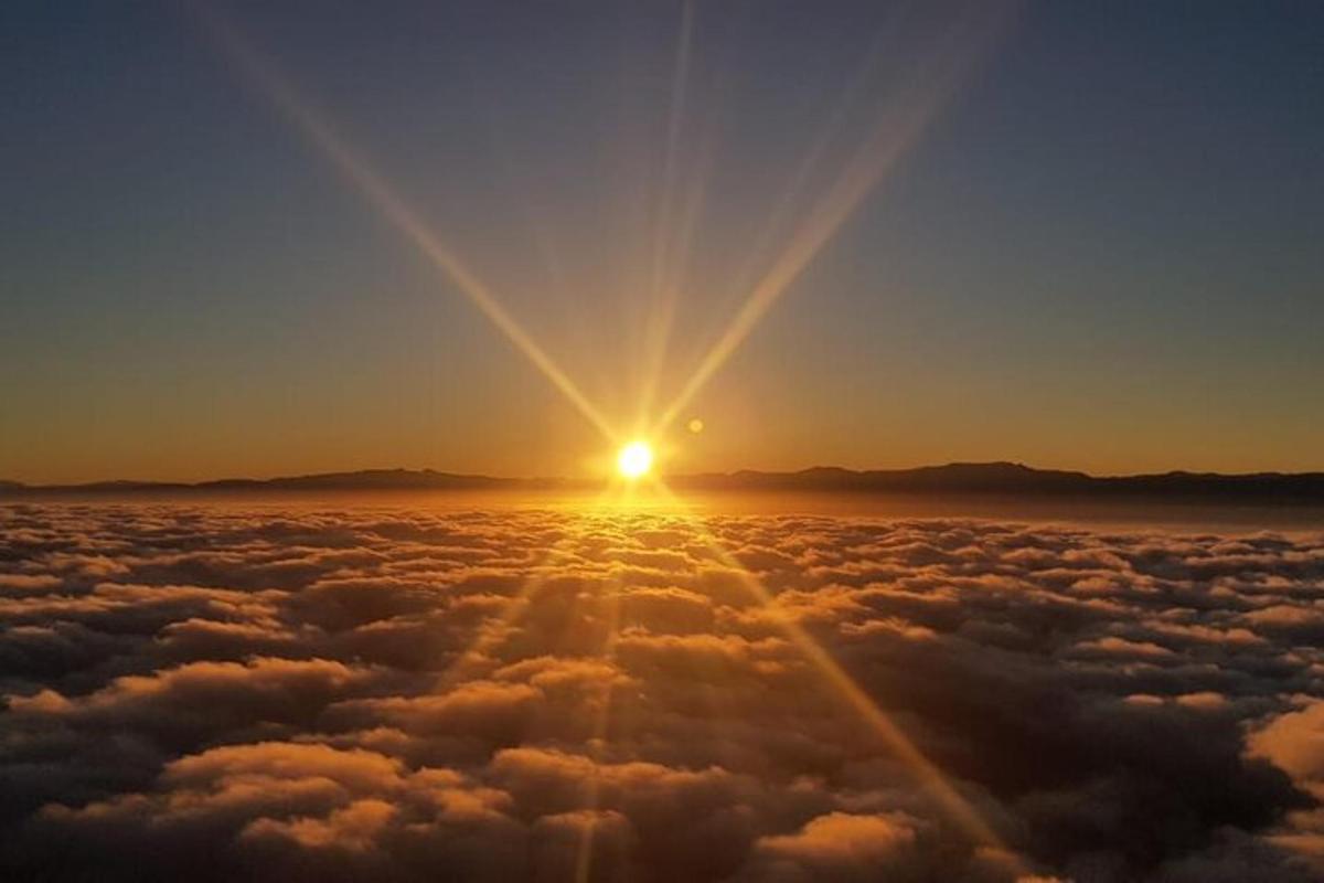 una vista del sole che sorge sopra le nuvole