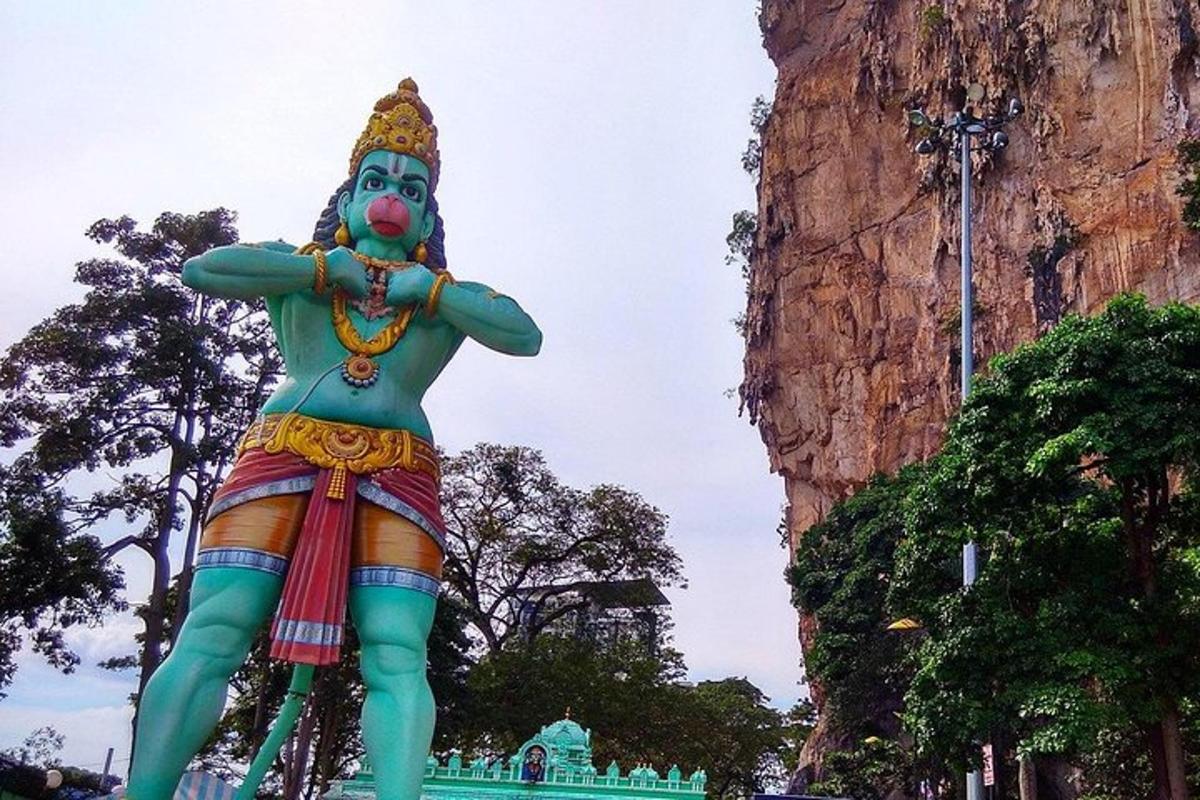 a large statue of a man standing next to a mountain
