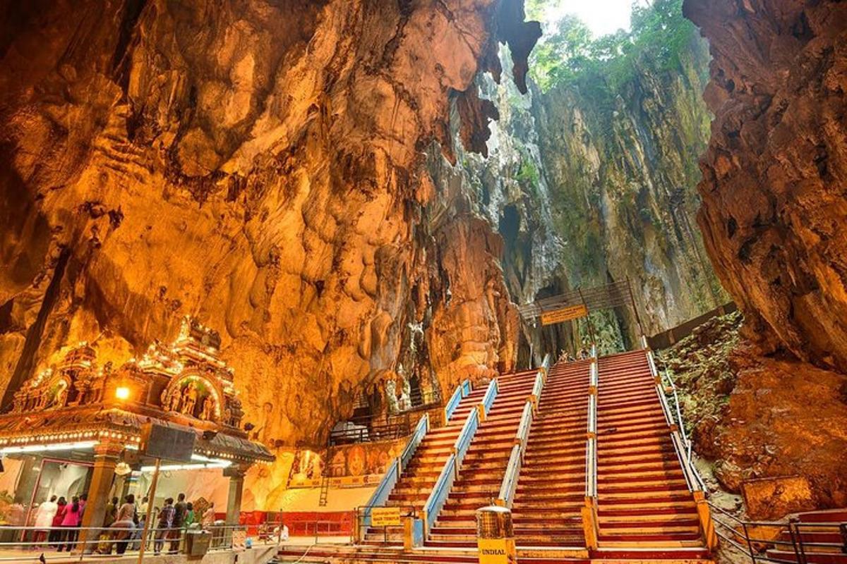 a cave with stairs in front of a mountain