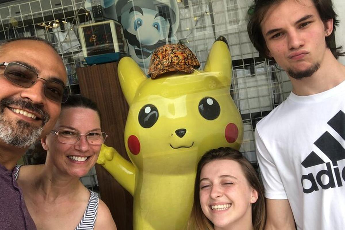 a group of people standing next to a pikachu statue