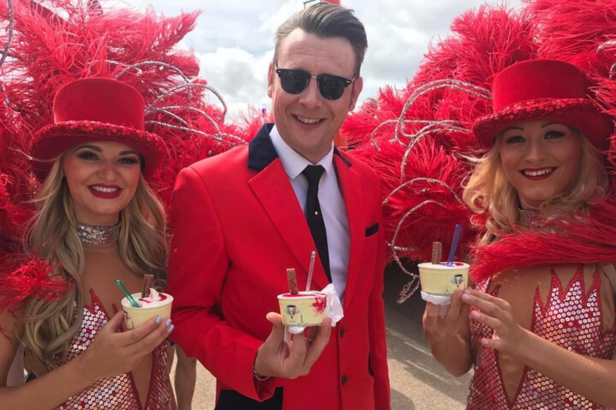 a man and two women wearing red hats and holding drinks