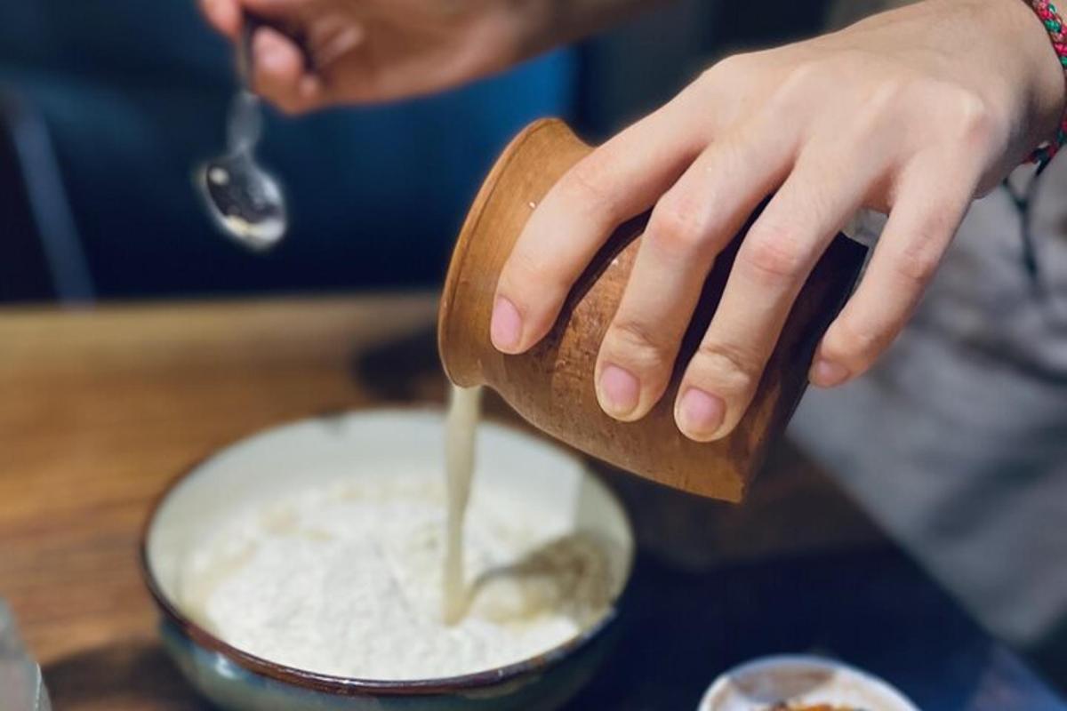 a person is pouring something into a bowl of food