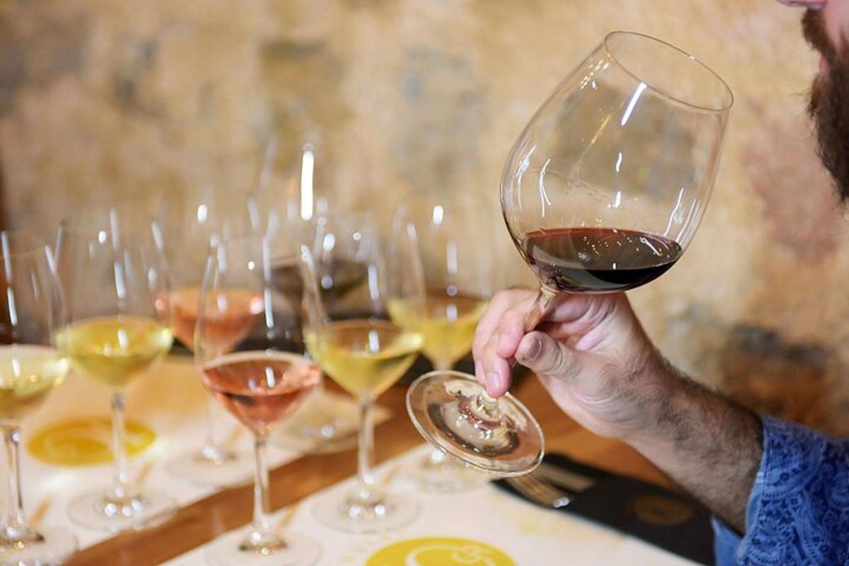 um homem segurando uma taça de vinho sobre uma mesa
