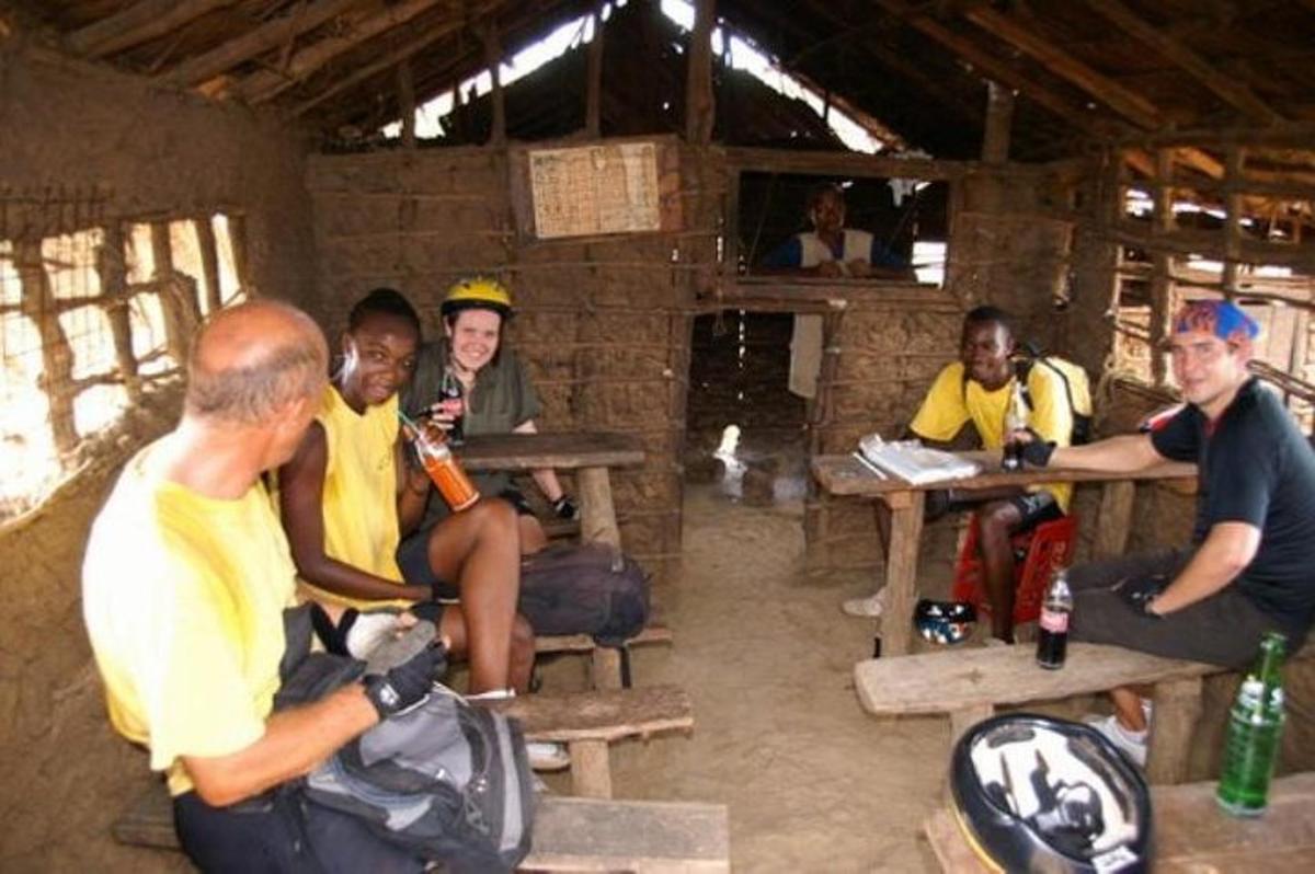 a group of men sitting at tables in a hut