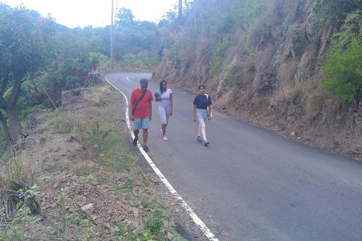 three men walking down a road on a mountain