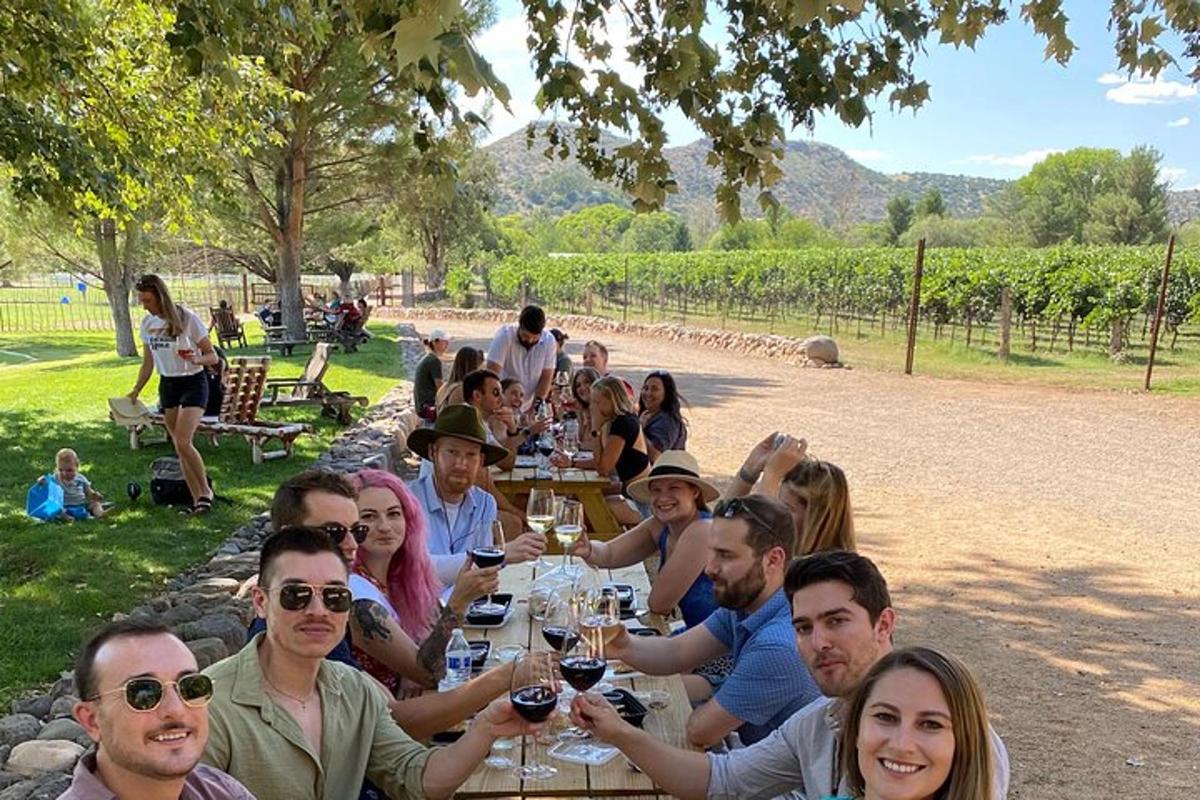 un gruppo di persone sedute a un tavolo con bicchieri di vino