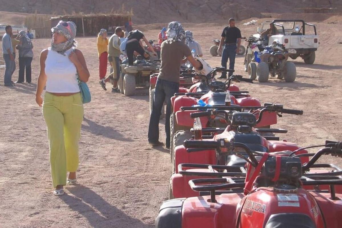 skupina lidí stojících kolem hromady motorek