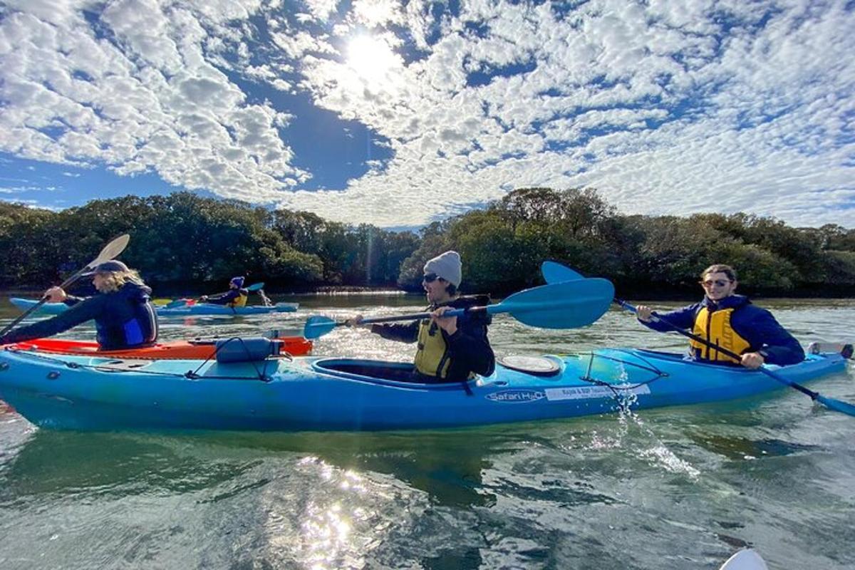 een groep mensen in een blauwe kajak op het water