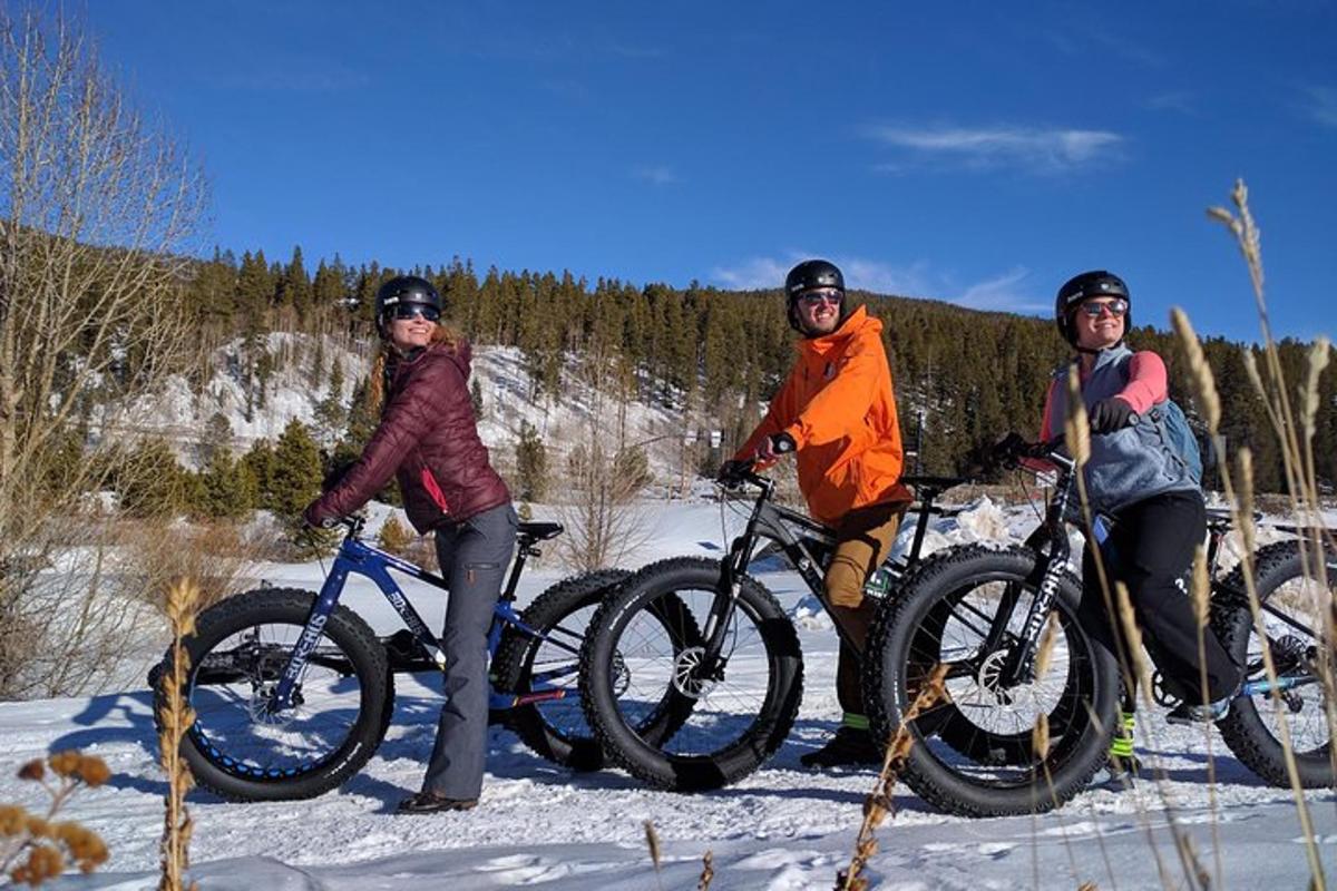 a group of three people on bikes in the snow