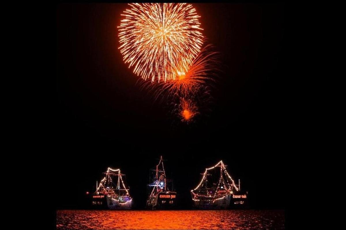 a group of boats in the water with fireworks
