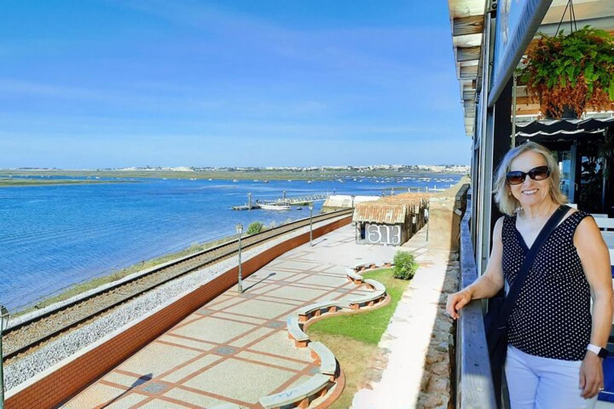 una donna in piedi su un balcone vicino all'acqua