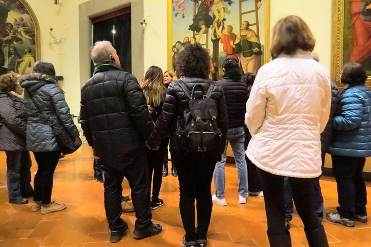 sekumpulan orang berdiri di muzium melihat seni