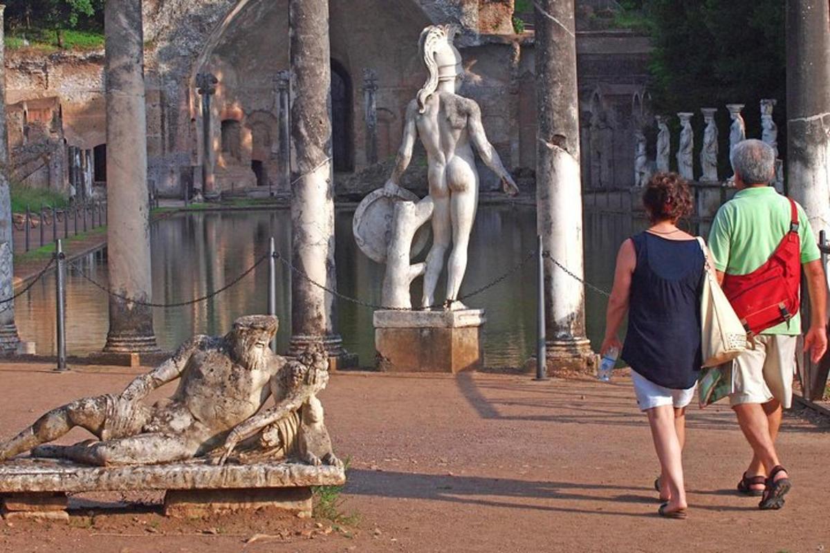two people walking past a statue of a woman