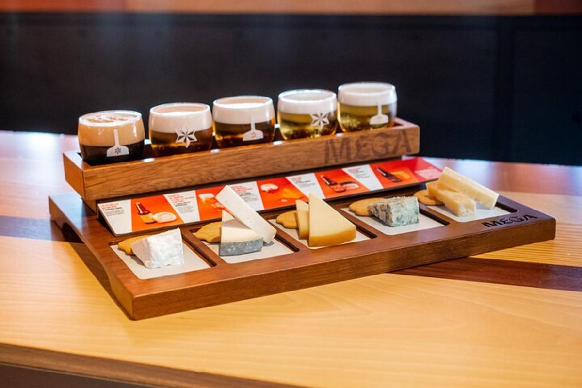 a tray of different types of cheese and jars ofbeer