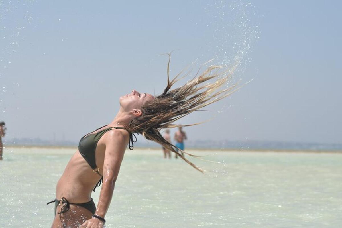 une femme se tient debout dans l'eau avec ses cheveux