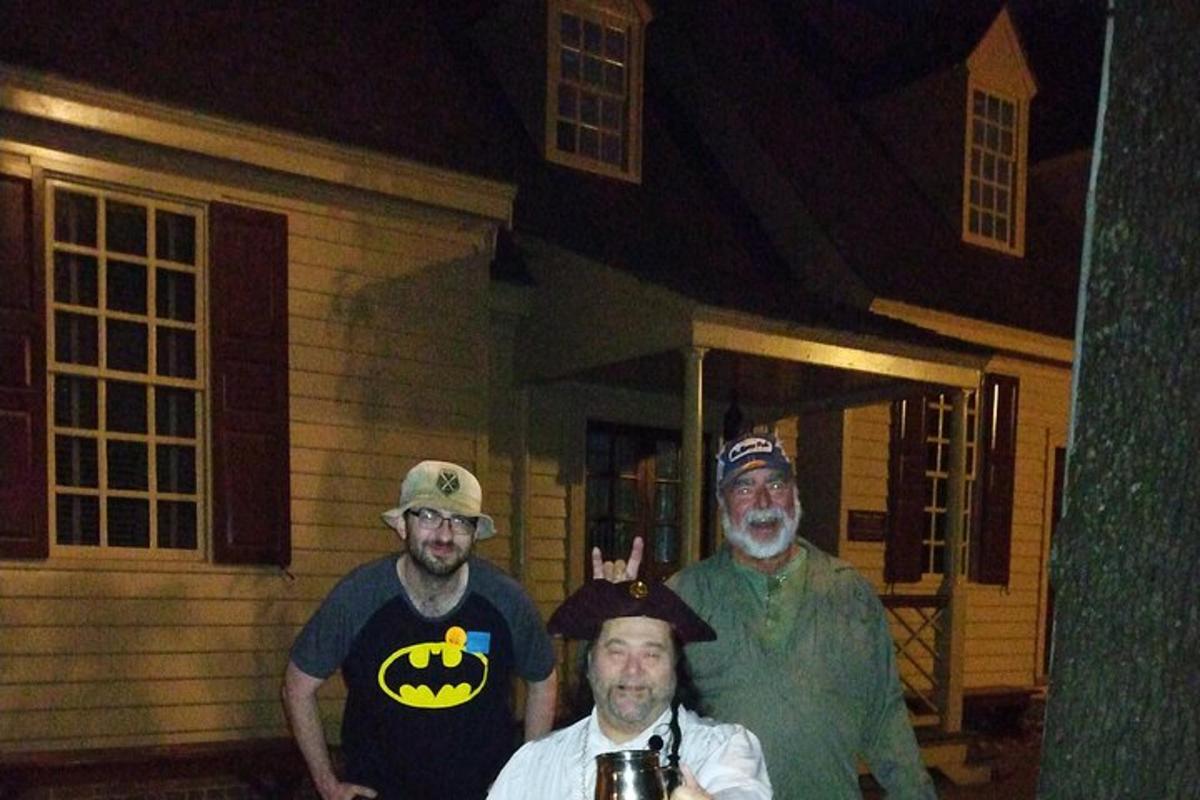a group of three men standing in front of a house