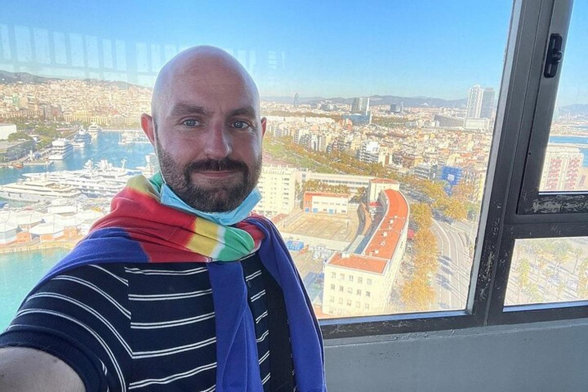 a man wearing a scarf standing in front of a window