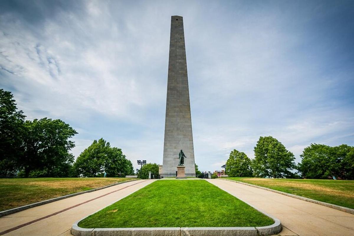 a monument with a statue in the middle of a park
