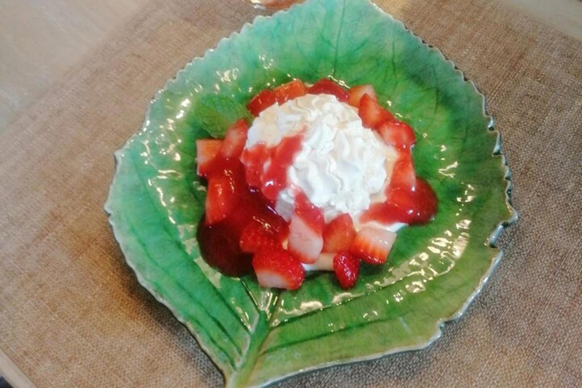 a green lettuce with strawberries and whipped cream