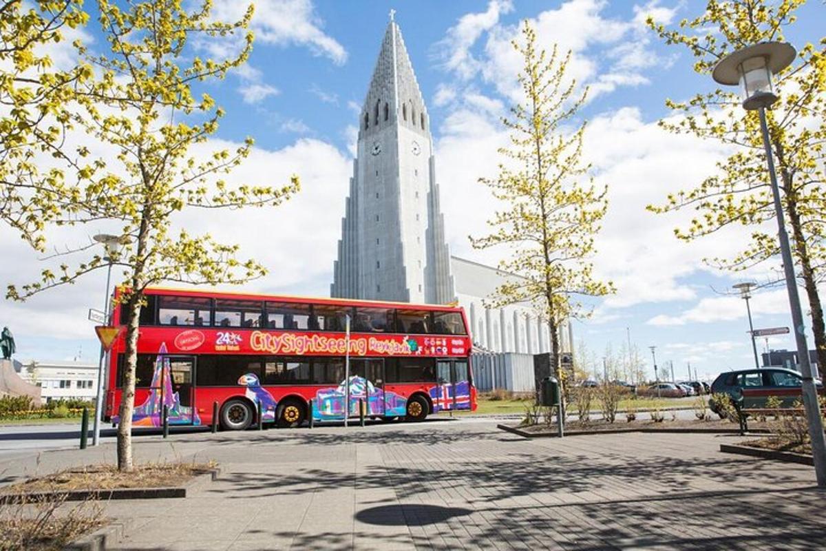 červený dvoupatrový autobus zaparkovaný před vysokou budovou