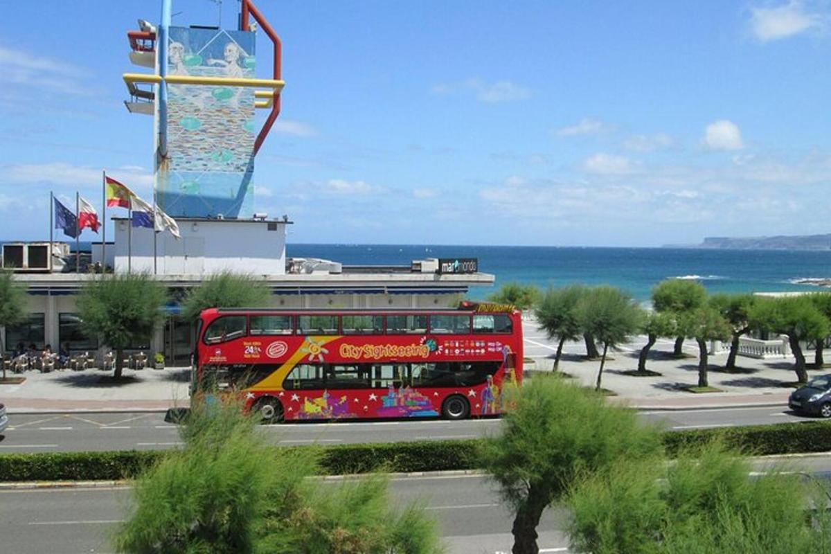 a red double decker bus driving down a street