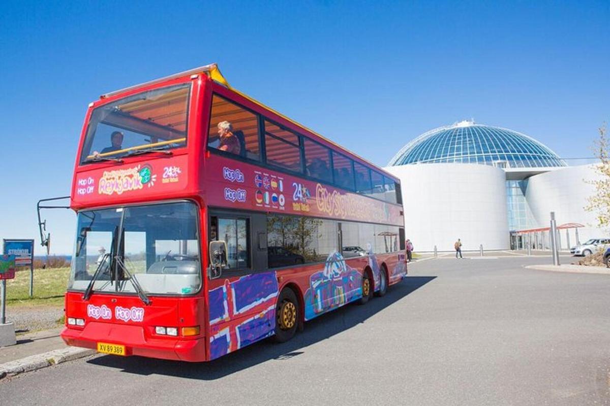 červený dvoupatrový autobus zaparkovaný před budovou