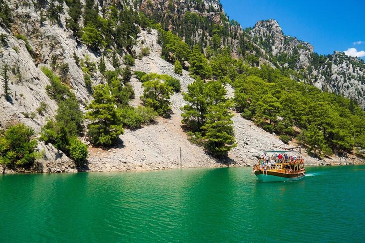 a boat in a body of water next to a mountain