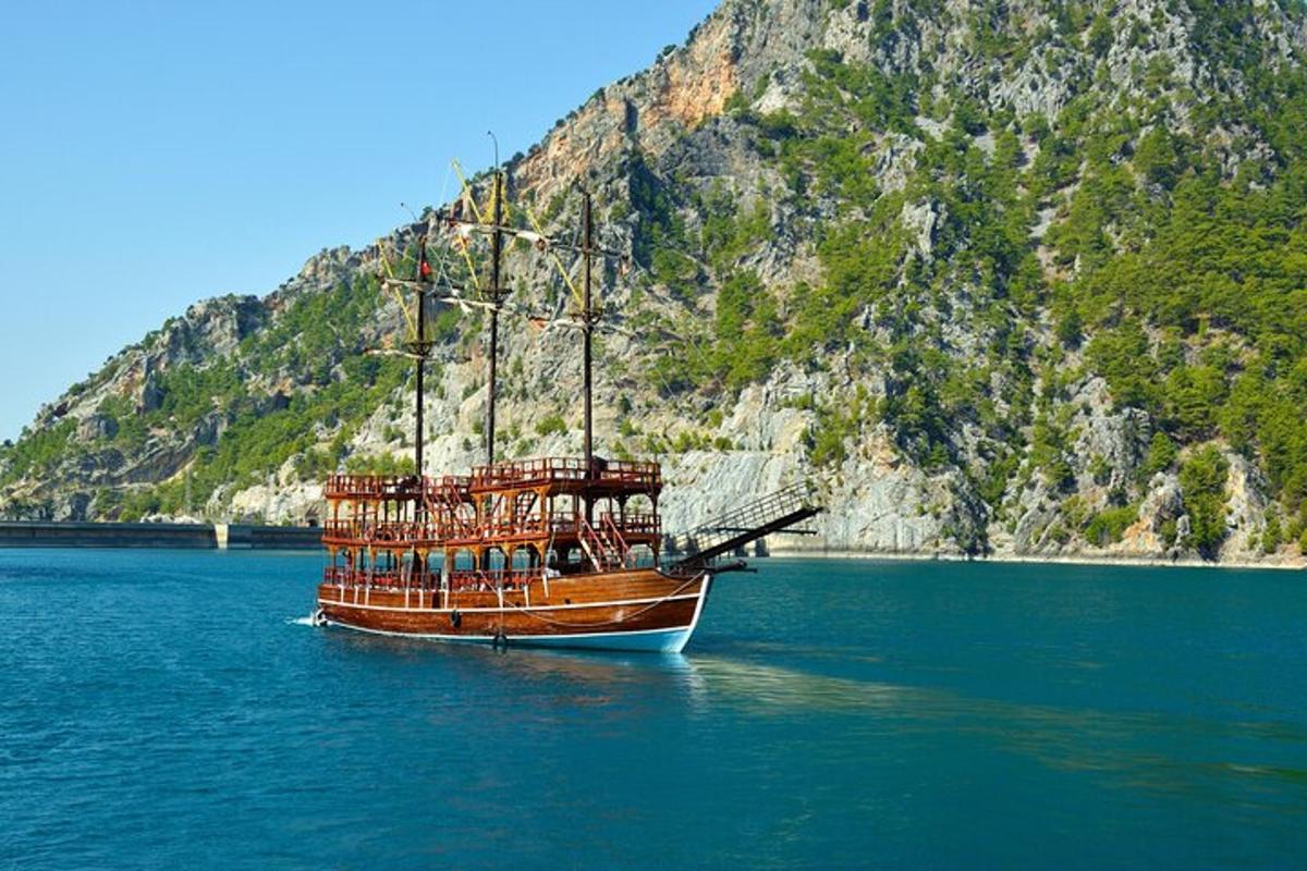 a boat sitting in the water next to a mountain