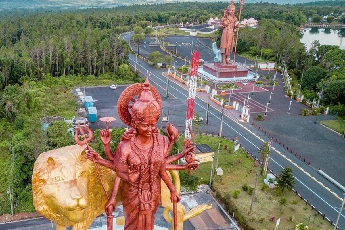 una statua di una donna in piedi accanto a una strada