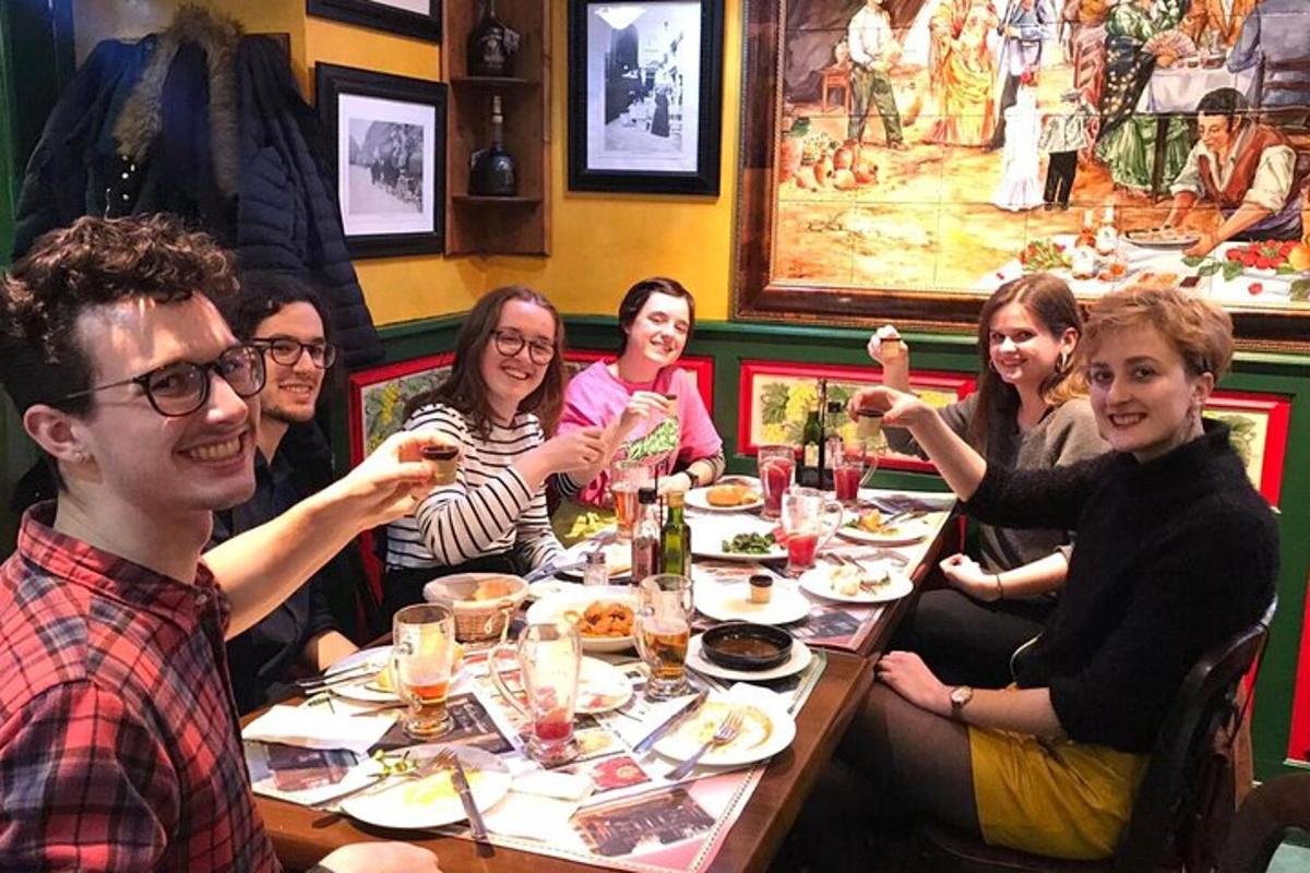 un gruppo di persone sedute attorno a un tavolo che mangiano