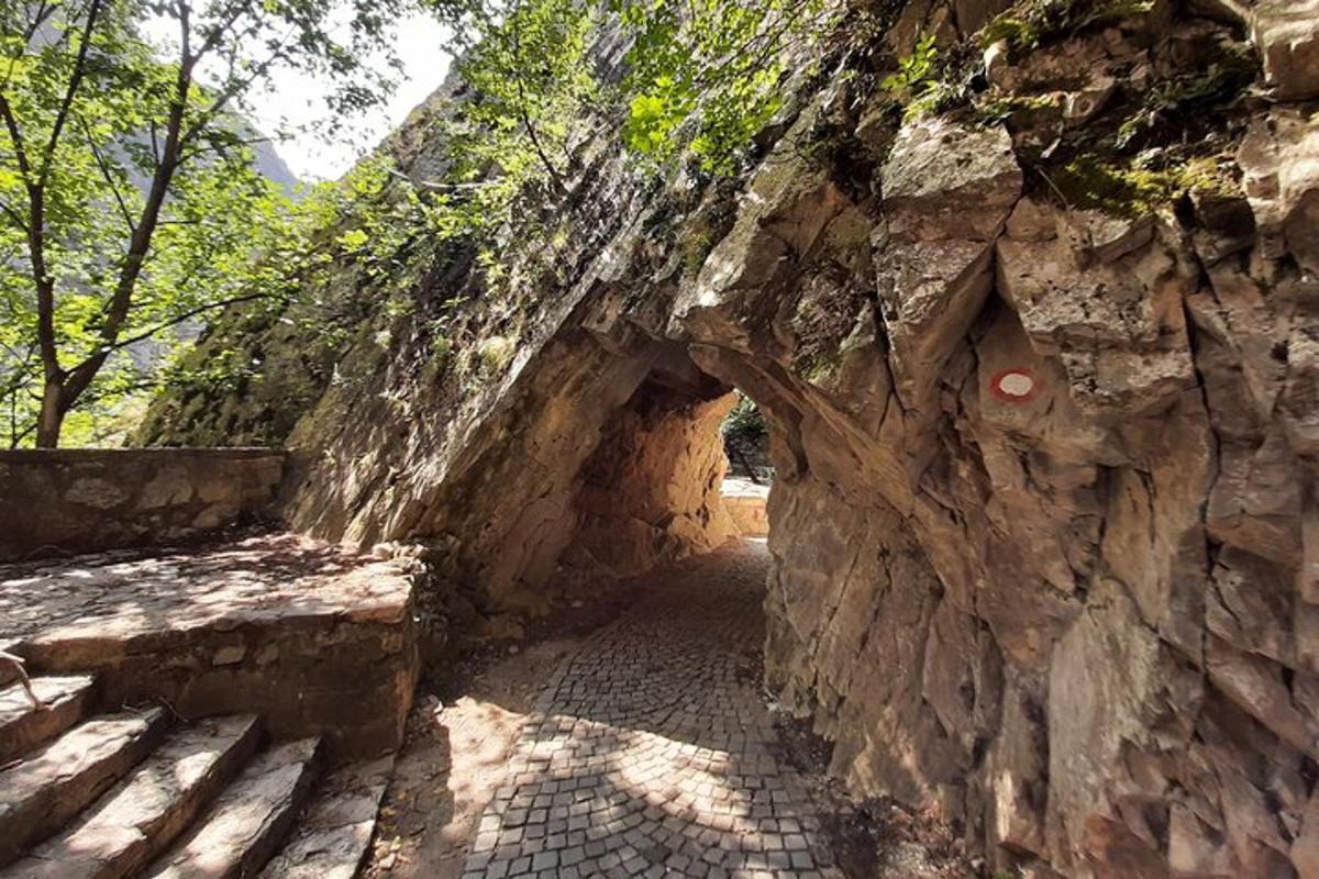 an entrance to a stone wall with a stone tunnel