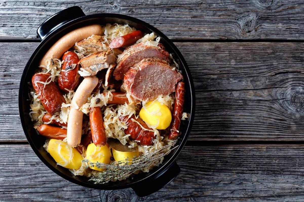 a pan filled with meat and vegetables on a wooden table