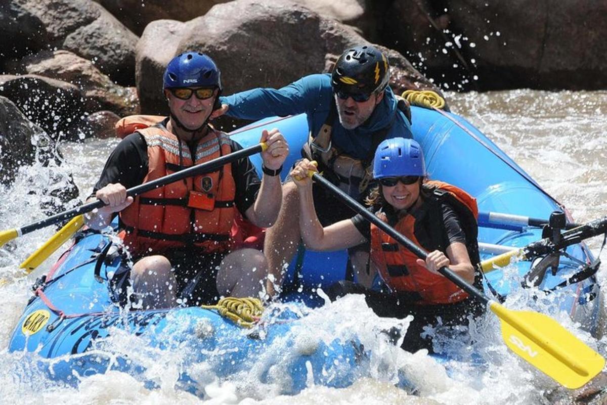 three people in a raft on a river