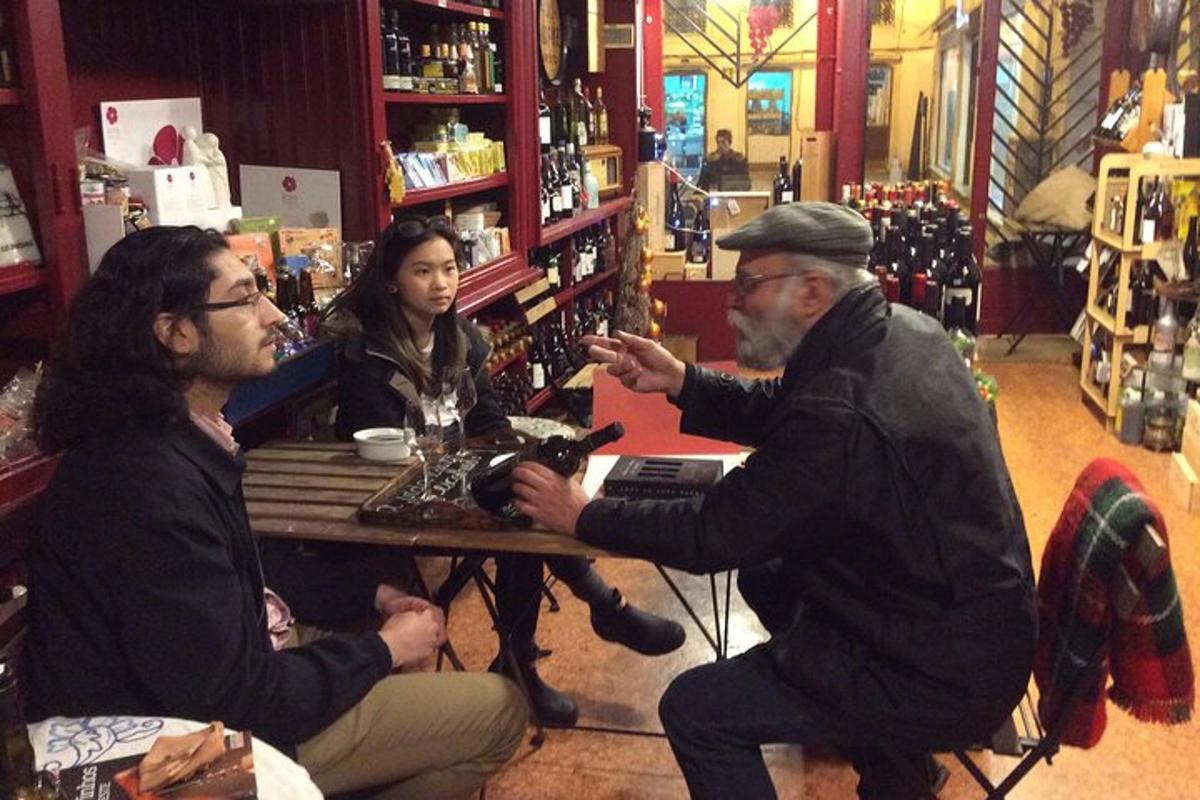 doi bărbați și o femeie așezați la o masă într-un bar