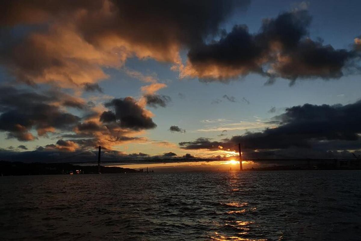 un coucher de soleil sur un plan d'eau avec un pont