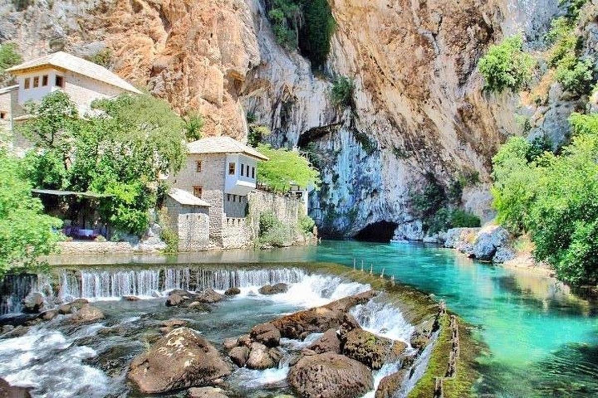 un fiume con un edificio sul fianco di una montagna