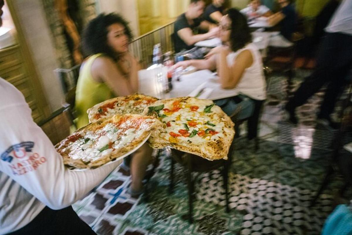 cilvēks, kas tur rokās divas lielas picas šķēles