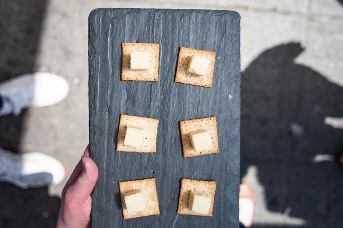 a person holding up a wooden block with food on it