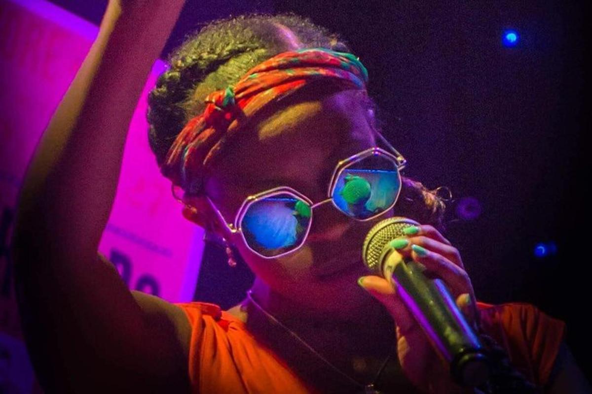 a woman wearing sunglasses and holding a microphone