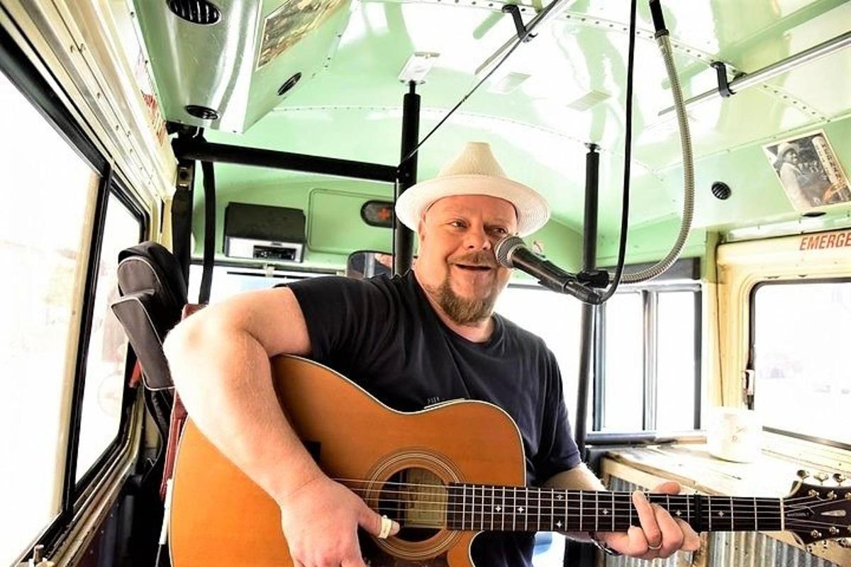 a man playing a guitar in a bus