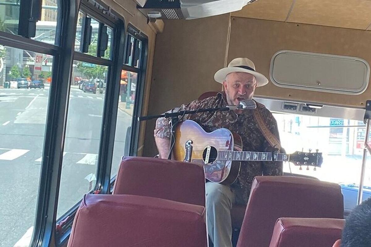 a man playing a guitar on a bus
