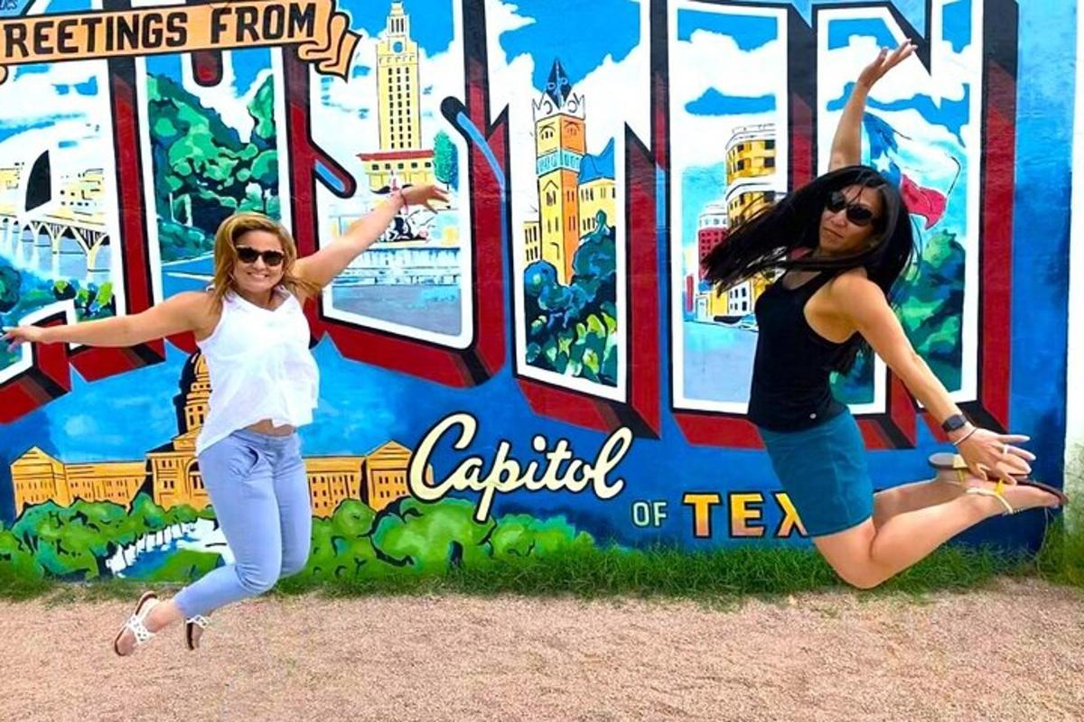 two women are jumping in front of a sign