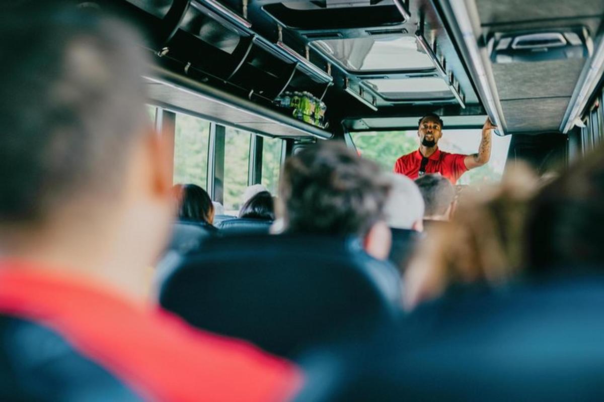 a man standing in front of a group of people on a bus